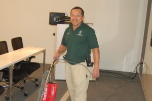 A man holding a red shopping bag and smiling.